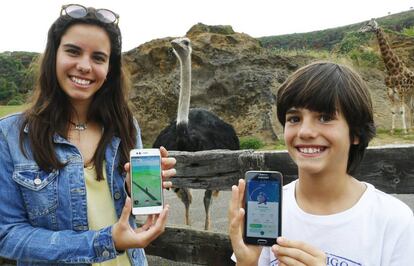 Los hermanos Marta y Gilberto Navarro, de 16 y 9 a&ntilde;os, en el parque de Cabarceno (Cantabria), con sus m&oacute;viles cazando Pok&eacute;mon.