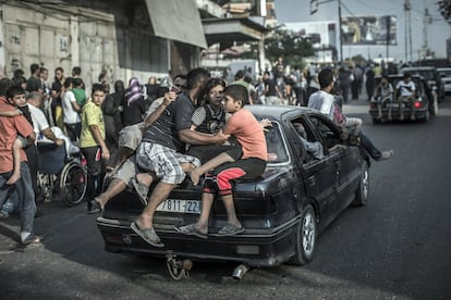 Palestinos saem do bairro de Shiyahiya montados em um carro, em 20 de julho de 2014.