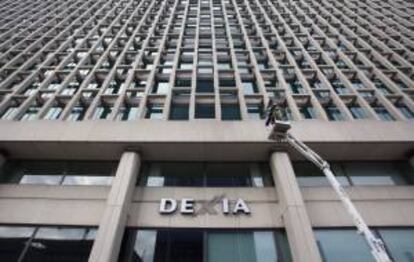 Los trabajadores retiran el logo del banco Dexia de la sede de la entidad en Bruselas, Bélgica. EFE/Archivo