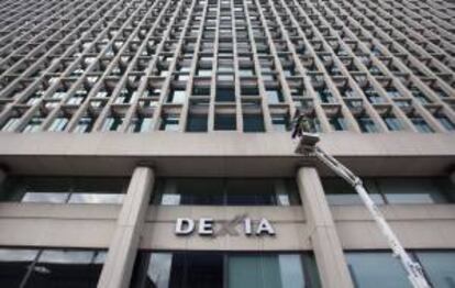 Los trabajadores retiran el logo del banco Dexia de la sede de la entidad en Bruselas, Blgica. EFE/Archivo