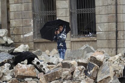 AUn niño toma fotografías con su teléfono móvil entre los escombros de edificios derruidos por una explosión en la zona rebelde de Azaz (Siria) cerca de la frontera con Turquía, el 8 de enero de 2017.