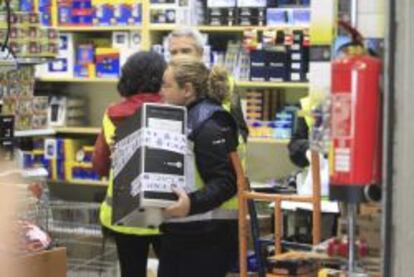 Efectivos de la polic&iacute;a proceden a requisar un ordenador en uno de los locales registrados en Madrid. 