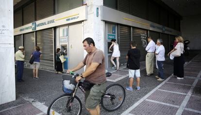 Varios clientes hacen cola ante una sucursal bancaria en el centro de Atenas.