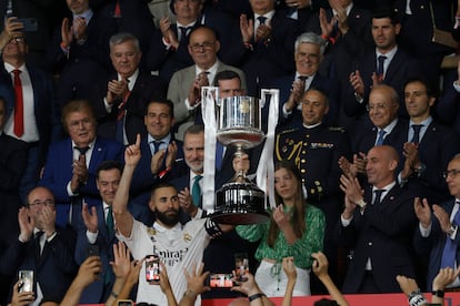 Karin Benzema recoge de manos del Reu Felipe VI la copa de campeones. 

