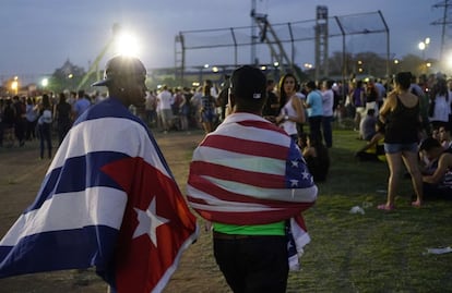 Dos jóvenes con las banderas de Cuba y Estados Unidos acceden al recinto del concierto..