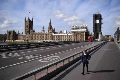 Un hombre camina por el puente de Westminster, con el Parlamento británico al fondo, en el centro de Londres, el 21 de marzo.