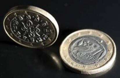 Una imagen muestra dos monedas de euro, una con el sello portugués (izquierda) y otra con el sello griego (derecha), colocadas en una mesa en Colonia, Alemania. EFE/Archivo