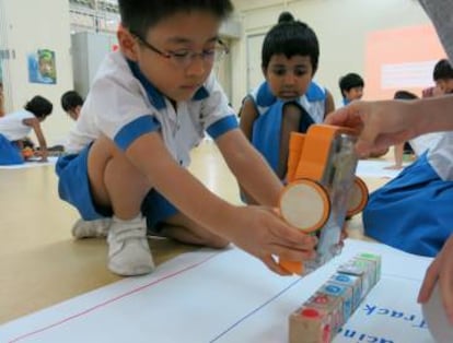 Criança da pré-escola brinca com o Kibo, um brinquedo robotizado.