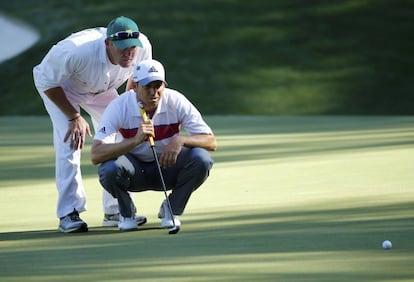 Sergio García y su caddie observan el green del hoyo 13.