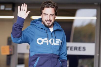 Alonso waves to the press as he leaves hospital.