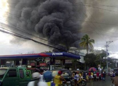 Imagen del humo saliendo del almacén de Leyte, en Filipinas, en el que este lunes se ha declarado un incendio que ha causado la muerte de al menos 23 personas.