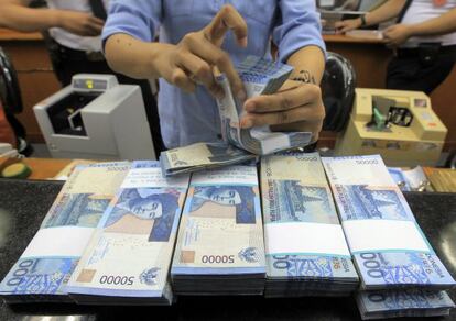Una trabajadora cuenta rupias en una oficina de cambio de divisas en Yakarta, Indonesia