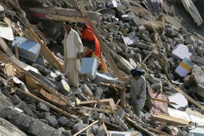 Habitantes de Muzaffarabad examinan los restos de su vivienda, totalmente destruida.