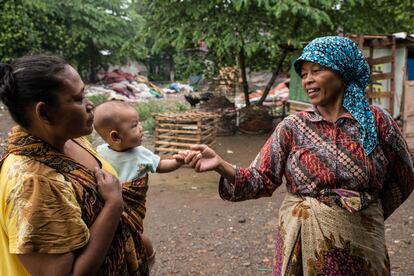 Mak Muji saluda a una mujer y a su niño mientras camina por Ciketingudik, el pueblo de los recicladores. 