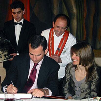 Don Felipe firma en el libro de honor del hostelero José María Ruiz.