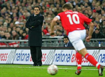 Fabio Capello observa desde la banda el avance de Gerrard con el balón.