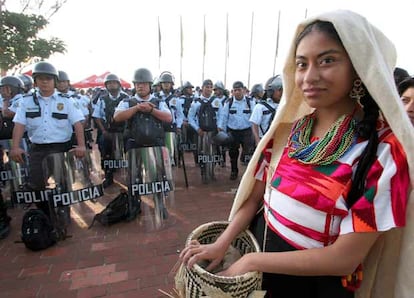 Un mujer perteneciente a una de las 16 etnias que participan en el festival indígena de Guelaguetza llegan al Cerro del Fortín, escenario de la tradicional celebración en medio de centenares de policías que custodian la ciudad mexicana de Oaxaca.