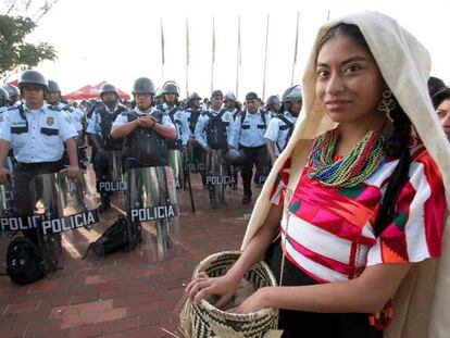 Un mujer perteneciente a una de las 16 etnias que participan en el festival indígena de Guelaguetza llegan al Cerro del Fortín, escenario de la tradicional celebración en medio de centenares de policías que custodian la ciudad mexicana de Oaxaca.