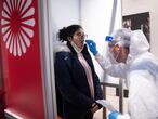 SCHOENEFELD, GERMANY - NOVEMBER 26: A medical worker takes a Covid-19 throat swab sample from a passenger at a testing station for Covid-19 at Berlin-Brandenburg Airport during the second wave of the coronavirus pandemic on November 26, 2020 in Schoenefeld, Germany. Centogene is operating a testing station as well as at airports in Frankfurt, Hamburg and Dusseldorf. The company promises the PCR test result will be available within 24 hours. Many passengers are taking advantage of the service in order to be allowed to avoid quarantine in their destination country. (Photo by Maja Hitij/Getty Images)