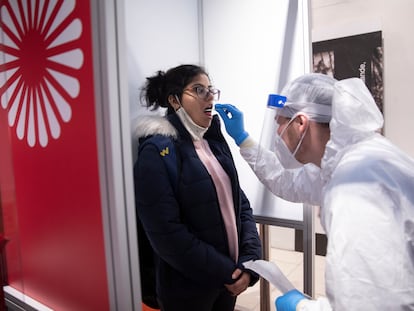 A medical worker takes a Covid-19 throat swab sample from a passenger at Berlin-Brandenburg Airport on November 26.