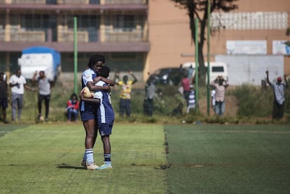 Duas jogadoras do Makolanders Ladies FC se abraçam comemorando um gol durante partida de futebol da Premier League Feminina.