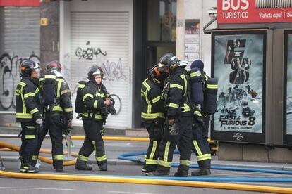 Bomberos trabajando para extinguir el incendio en el número 48 de Gran Vía.