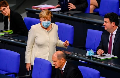 La canciller Angela Merkel se dirige este martes hacia el ministro de Finanzas, Olaf Scholz, a su llegada al Bundestag.