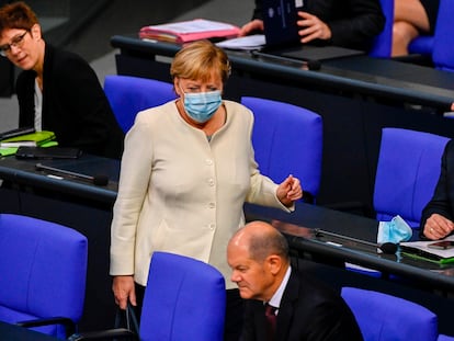 La canciller Angela Merkel se dirige este martes hacia el ministro de Finanzas, Olaf Scholz, a su llegada al Bundestag.