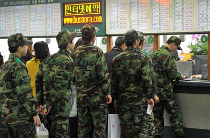 Soldados surcoreanos hacen cola para comprar billetes de autobús para reincorporarse a sus unidades después del ataque de Corea del Norte.