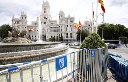 La fuente de la Cibeles, en Madrid, rodeada de vallas y banderas de España.