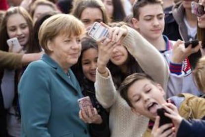 La canciller alemana, Angela Merkel (i), posa para una "autofoto" junto a dos estudiantes durante una visita al Colegio Europeo Robert-Jungk en el ámbito del "Día del proyecto europeo", en Berlín.