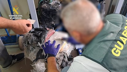 Un agente de la Guardia Civil abriendo uno de los fardos de coca incautados en Barbate.