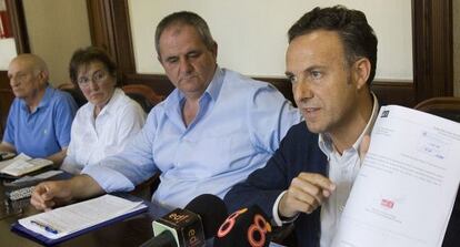 El portavoz del PSOE, David de la Encina, muestra la moción de la oposición en El Puerto.