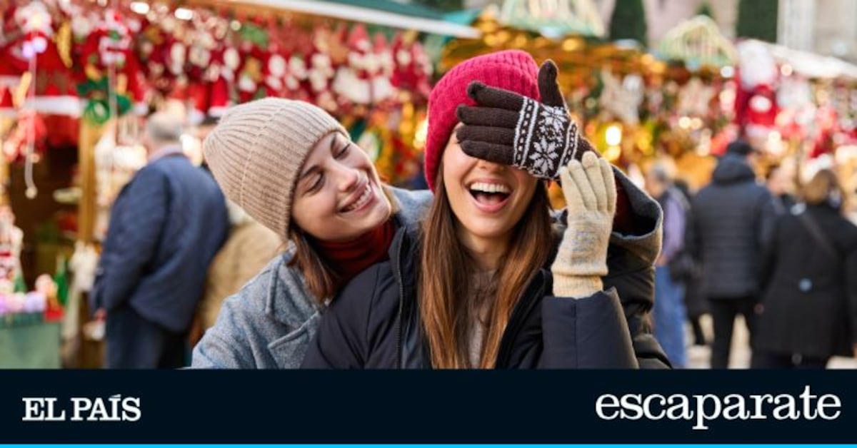Dos amigas riendo juntas en un mercado navideño