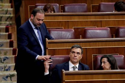El líder del PSOE, Pedro Sánchez (c), la portavoz del partido en el Congreso, Margarita Robles, y el secretario de Organización, José Luis Ábalos (i), conversan durante el debate de la moción de censura.