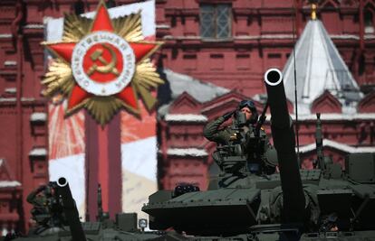 Un miembro de la tripulación de un tanque T-80 BVM saluda durante un desfile militar del Día de la Victoria en la Plaza Roja de Moscú.