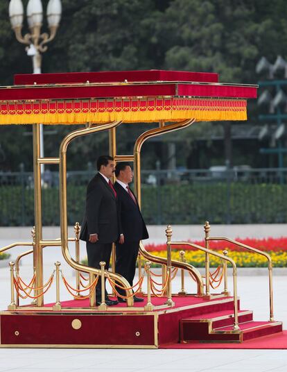 Nicolás Maduro y su homólogo chino, Xi Jinping, de pie en un podio mientras escuchan sus himnos nacionales durante la ceremonia de bienvenida a Pekín.