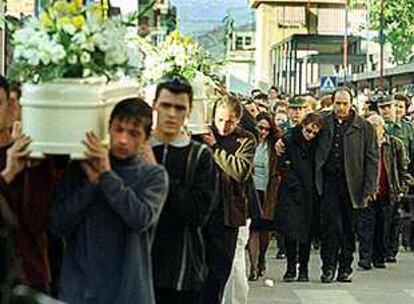 Los padres de los niños asesinados caminan tras los féretros en el cortejo fúnebre hasta el cementerio.