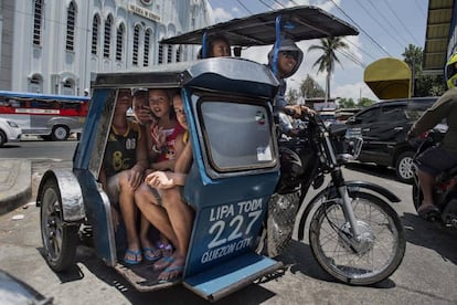 Varias mujeres viajan en un triciclo, los mototaxis de Filipinas.