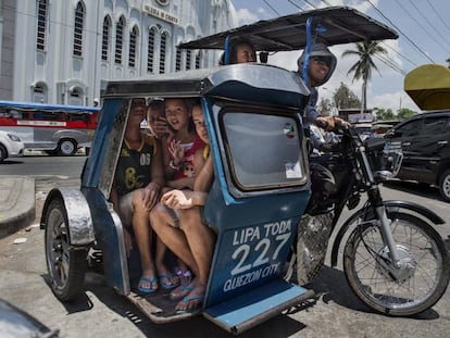 Varias mujeres viajan en un triciclo, los mototaxis de Filipinas.