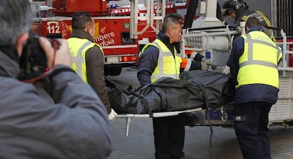 Retirada del cuerpo de uno de los indigentes fallecidos en un edificio abandonado de Valencia.