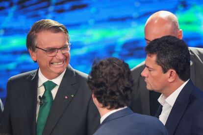 El presidente y candidato a la reelección de Brasil, Jair Bolsonaro, reacciona con el exministro de Justicia de Brasil, Sergio Moro durante el debate.