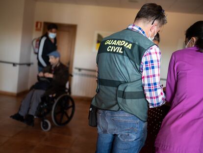 Un guardia civil interroga a un grupo de personas en la residencia de ancianos de Moraleja de Sayago (Zamora) este jueves.