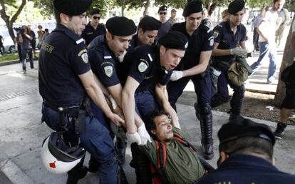 La polic&iacute;a detiene a uno de los indignados en la plaza Syntagma de Atenas. 