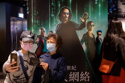 Moviegoers take a selfie in front of a movie banner for ‘The Matrix Resurrections’ at a cinema in Hong Kong.