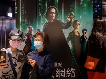 Asistentes a una sesión de la nueva entrega de 'Matrix' se fotografían ante su cartel en Hong Kong el pasado 22 de diciembre.
