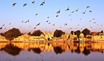 Esta imagen nos trasporta a la ciudad de Jaisalmer (India). La envió David de Andrés desde allí: "El día madruga. La ciudad cardinalmente flanqueada por el desierto del Tar nos abre sus puertas mientras abrimos los ojos. El lago, manso, bordea el color violeta para alimentar a las aves que beben el primer sorbo de la mañana. El sol amarillea el cielo, y el fuerte observa lejano lo que nosotros respiramos de cerca. Silencio en Jaisalmer. Inauguramos las horas".