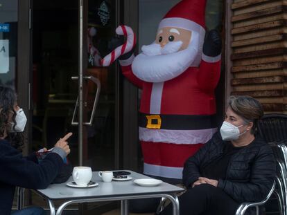 Dos personas conversan con la mascarilla puesta mientras se toman algo en la terraza de un bar, este miércoles en Ourense.