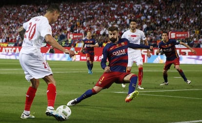 Gerard Piqu s'enfronta al jugador del Sevilla Vitolo.