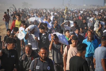 En medio del caos decenas de palestinos transportan cajas y bolsas con paquetes de alimentos y ayuda humanitaria en Rafah, al sur de la Franja de Gaza.